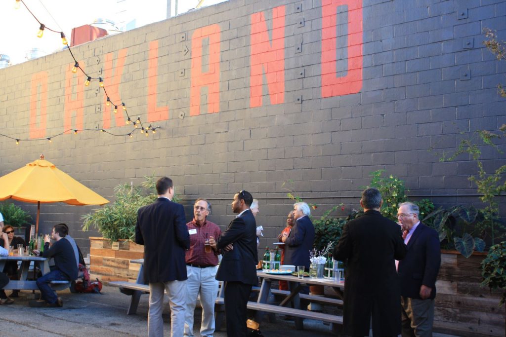 Event with Oakland mural in background