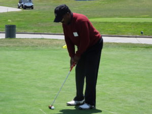 man putting with a gavel on the green